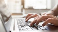 Hands typing on a computer.